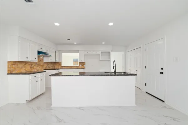 a kitchen with stainless steel appliances granite countertop a stove a sink and a refrigerator