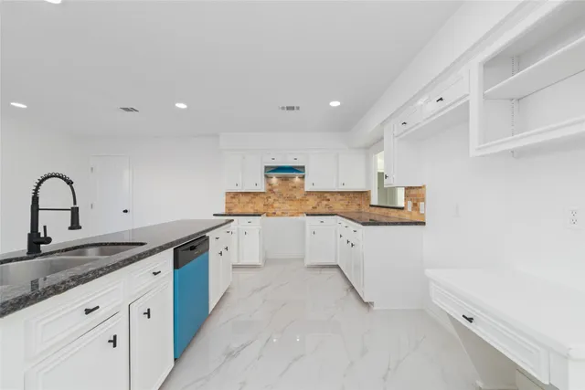 a kitchen with granite countertop white cabinets and white appliances