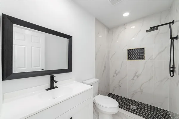 a bathroom with a sink a toilet and shower
