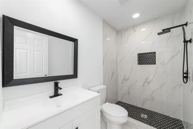 a bathroom with a sink a toilet and shower