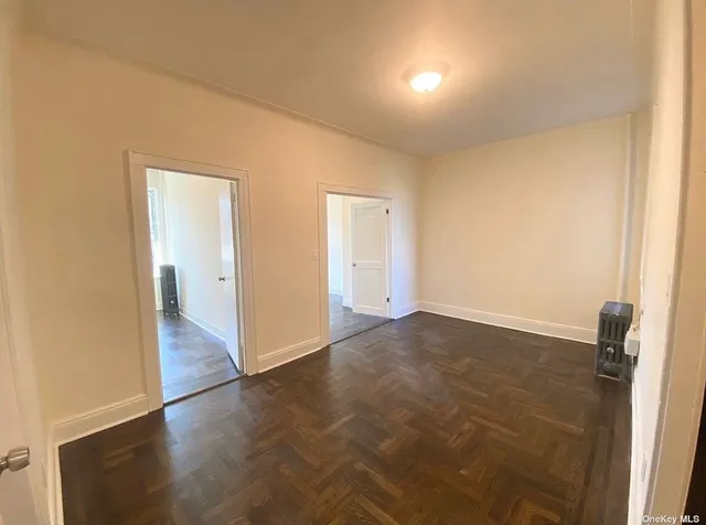 an empty room with wooden floor and bathroom