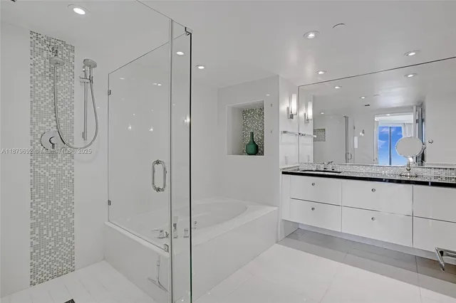 a bathroom with a granite countertop sink a mirror a bathtub and shower