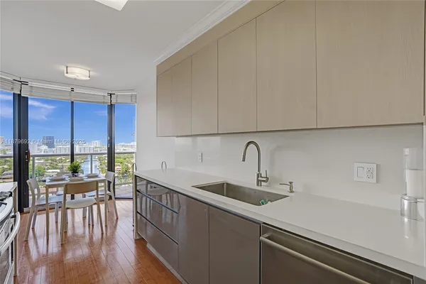 a kitchen with a sink a counter top space and living room area