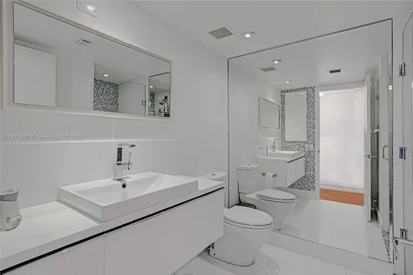 a bathroom with a sink toilet vanity and shower