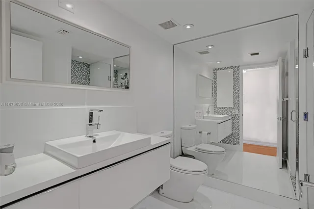 a bathroom with a sink toilet vanity and shower
