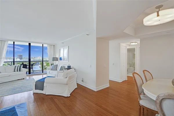 a living room with furniture kitchen view and a large window