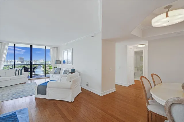 a living room with furniture kitchen view and a large window