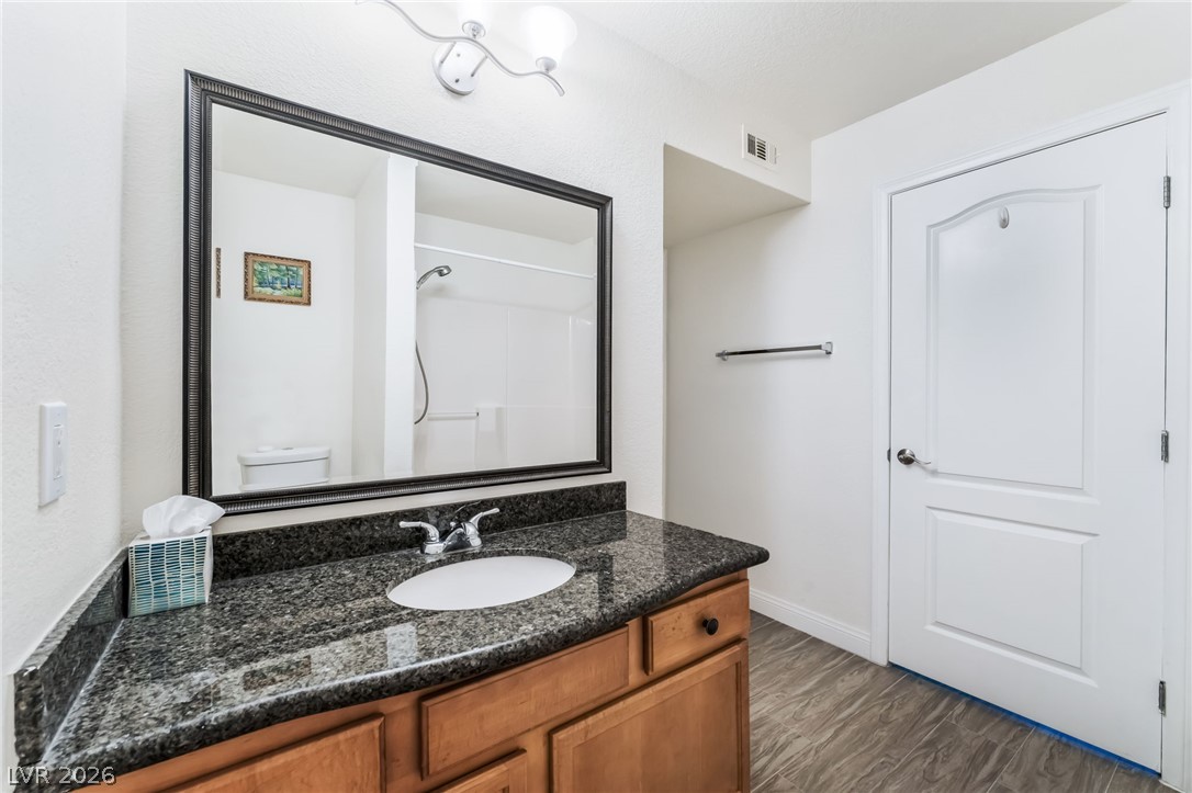 3145 East Flamingo Road, Unit 1092 Las Vegas, NV 89121 - Photo 21 of 33 A refined bathroom featuring a spacious vanity with granite counters and a large mirror.