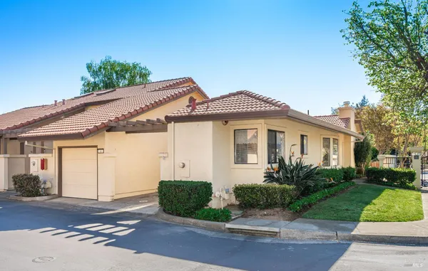 a front view of a house with a yard and potted plants
