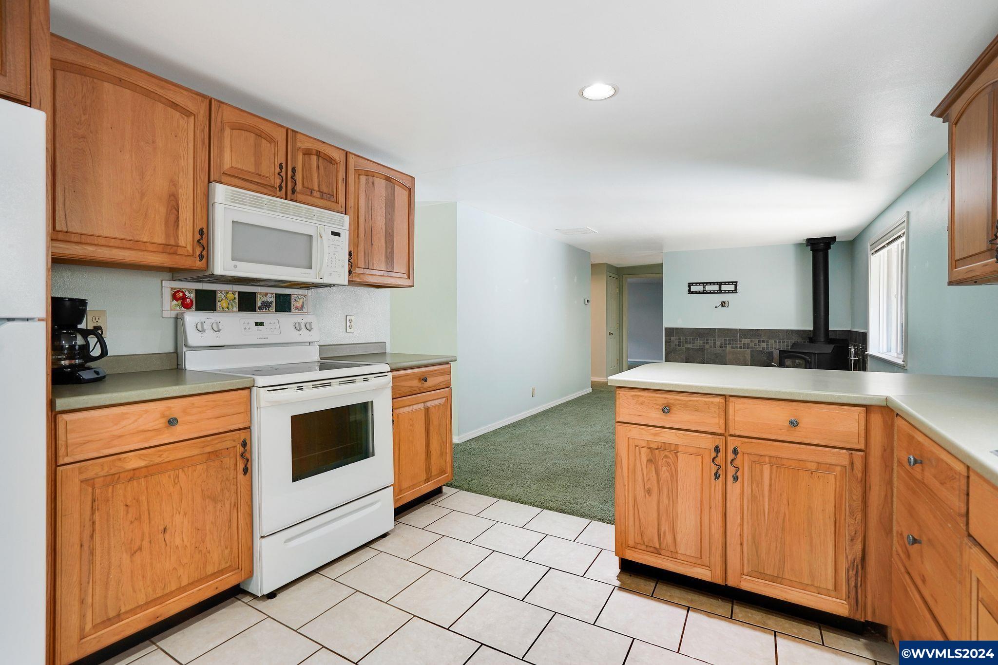 1787 Cochrane Lane Dallas, OR 97338 - Photo 26 of 42 a kitchen with granite countertop white cabinets and white appliances