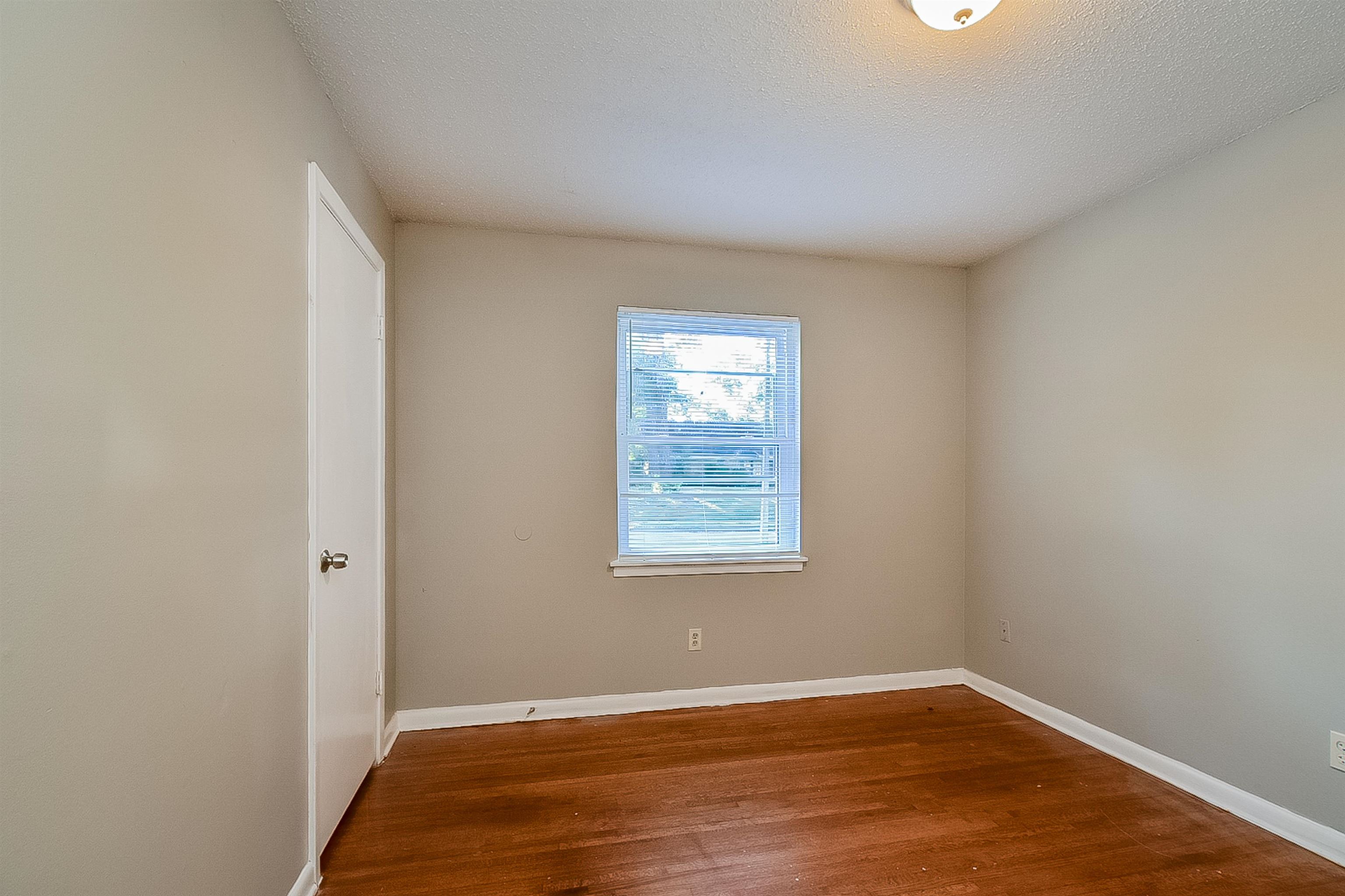 3020 Capri Road Memphis, TN 38118 - Photo 10 of 14 Unfurnished room featuring dark wood finished floors and a textured ceiling