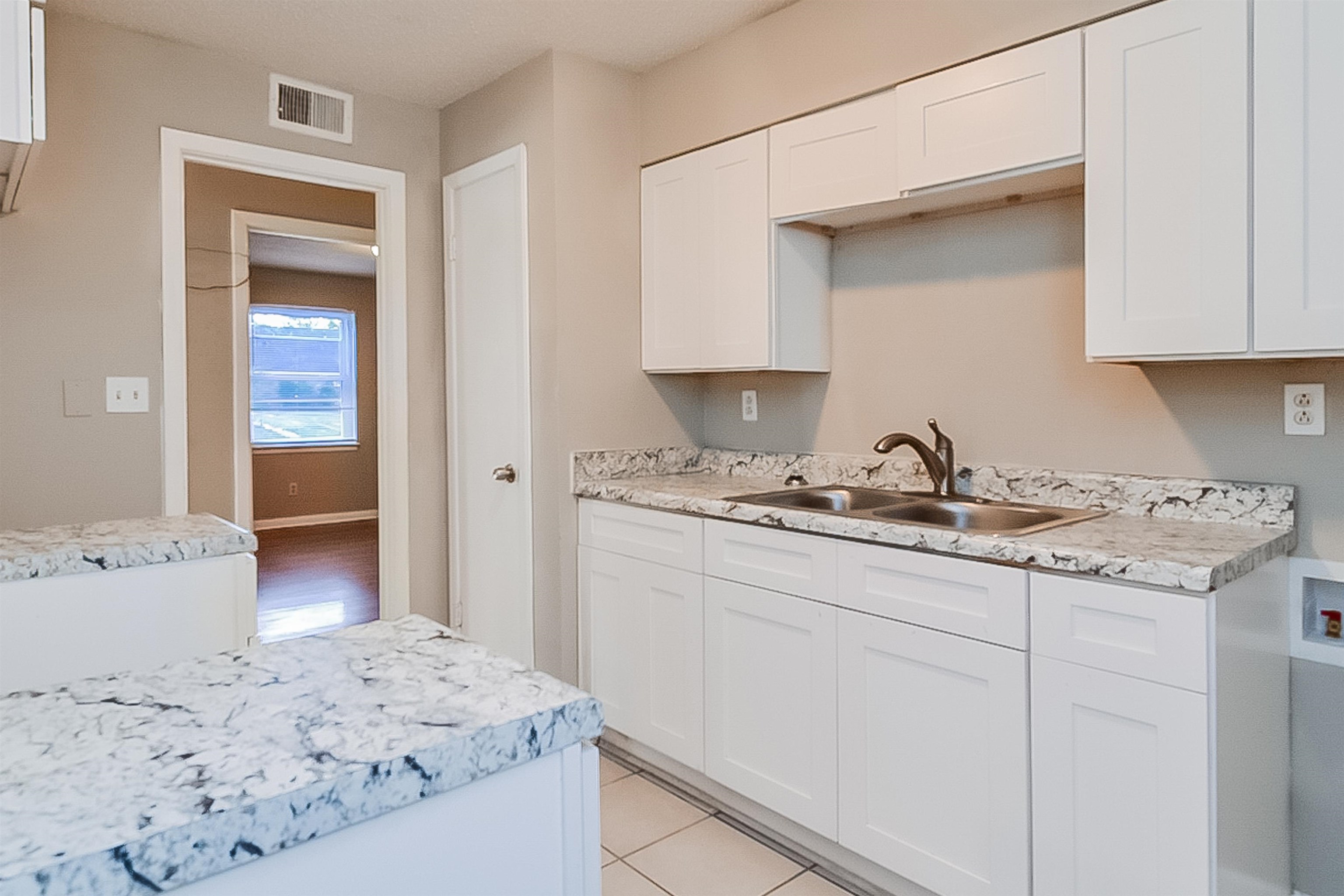 3020 Capri Road Memphis, TN 38118 - Photo 12 of 14 Kitchen with light countertops, white cabinets, and light tile patterned floors