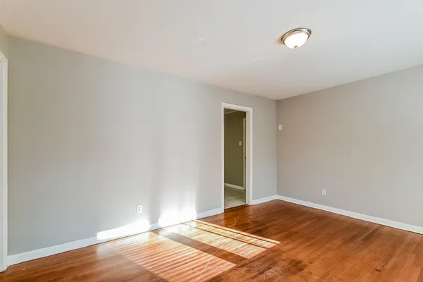 a view of a room with wooden floor and white walls