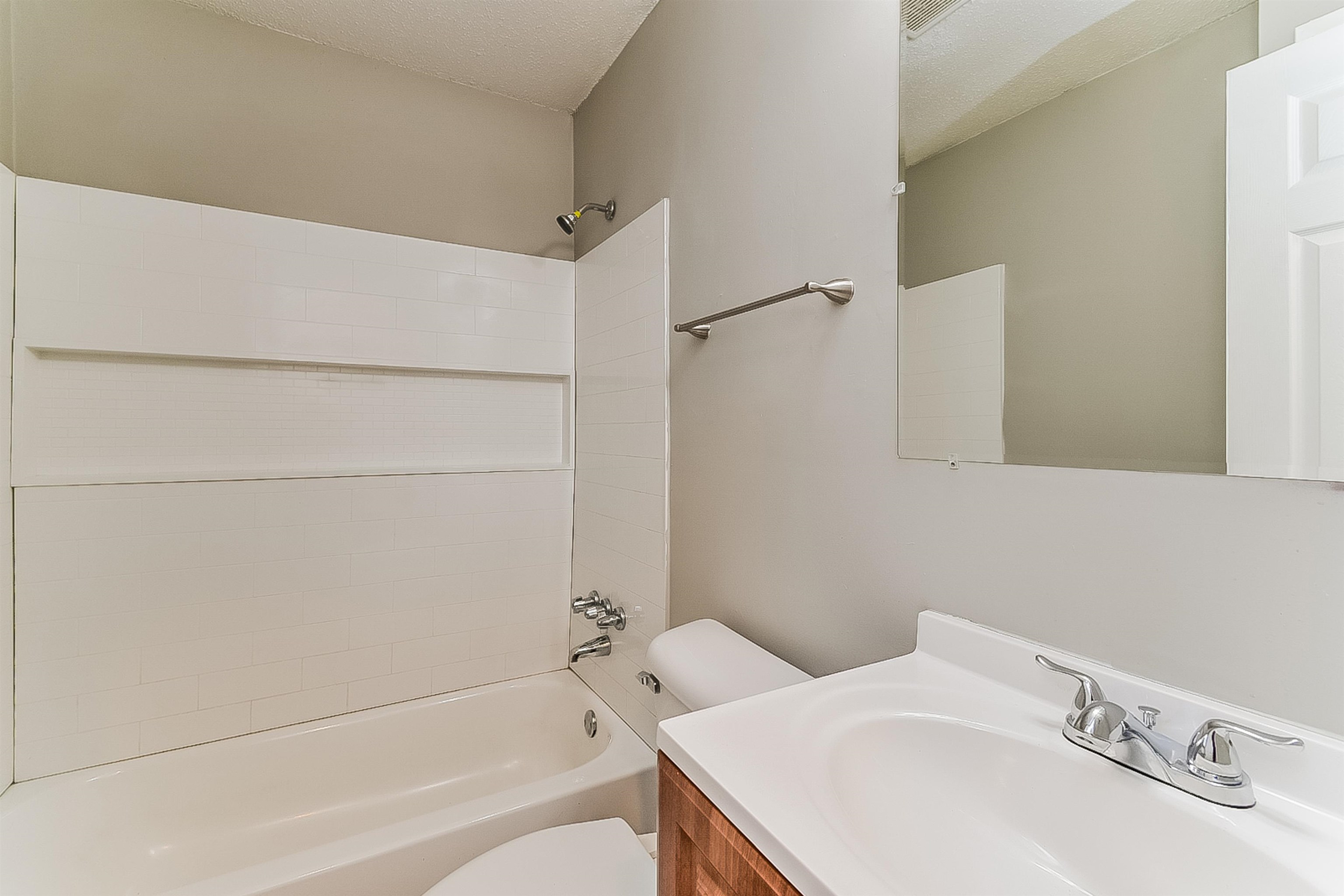 3020 Capri Road Memphis, TN 38118 - Photo 8 of 14 Bathroom with tub / shower combination, vanity, and a textured ceiling