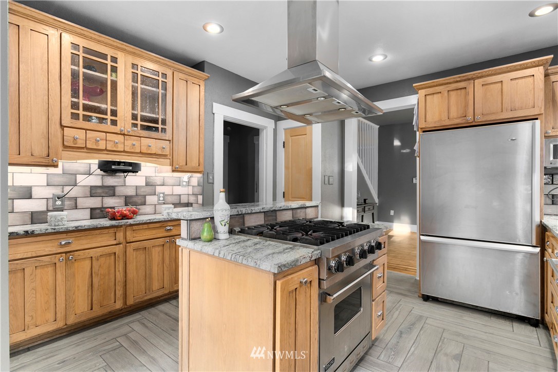1625 27th Avenue Seattle, WA 98122 - Photo 14 of 40 a kitchen with stainless steel appliances granite countertop a stove a sink and a refrigerator
