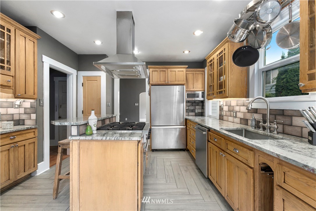 1625 27th Avenue Seattle, WA 98122 - Photo 18 of 40 a kitchen with stainless steel appliances granite countertop a sink a stove and a refrigerator