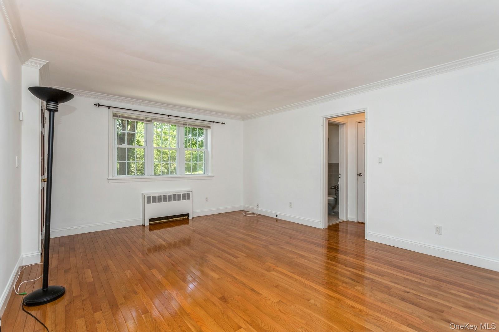 51 Cross Street, Unit 3A Yonkers, NY 10708 - Photo 6 of 17 Room featuring radiator heating unit, light wood-type flooring, and crown molding