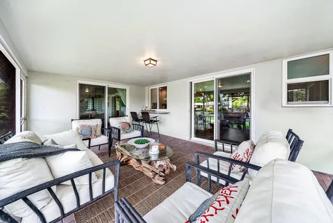a living room with patio furniture and a garden