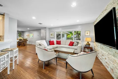 a living room with furniture a flat screen tv and a large window