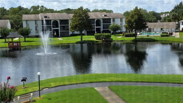 a view of a lake with a yard and potted plants