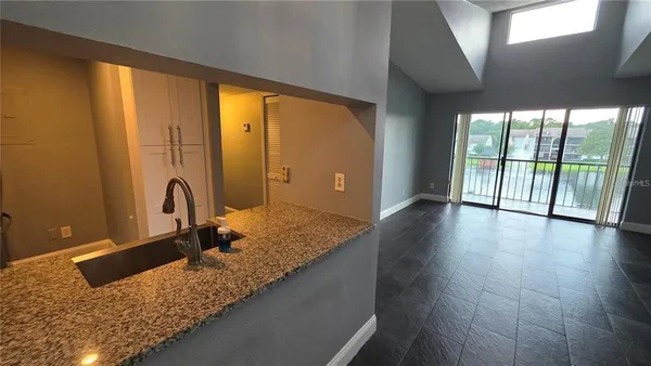 a bathroom with a granite countertop sink and a large mirror