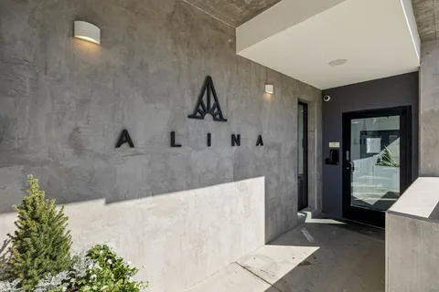 a hallway with white cabinets and wooden floor