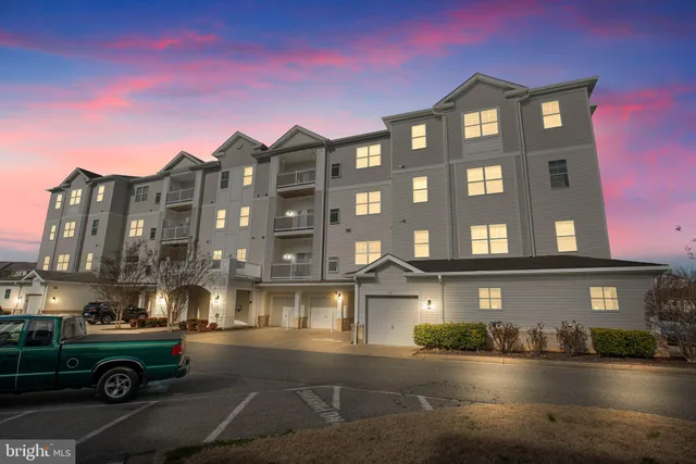 a front view of a building with lot of cars parked