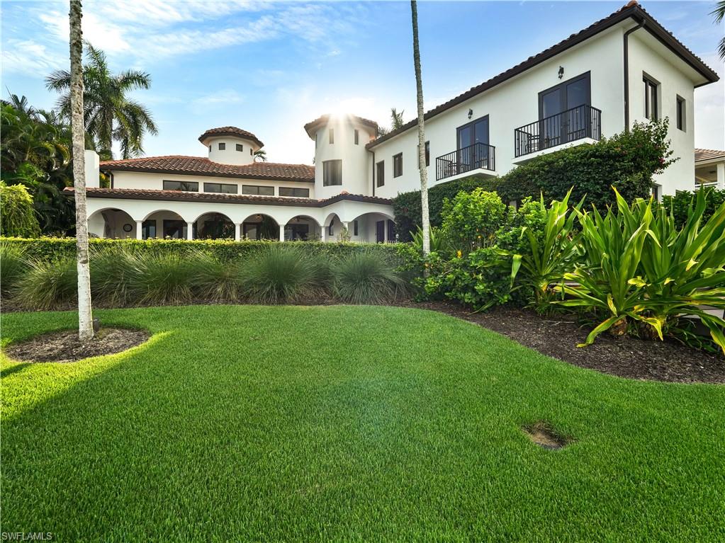 2535 Tarpon Road Naples, FL 34102 - Photo 47 of 50 Mediterranean-style residence featuring a terracotta tile roof, white stucco exterior, arched covered patio, private swimming pool, and a multi-slip dock with a boat lift
