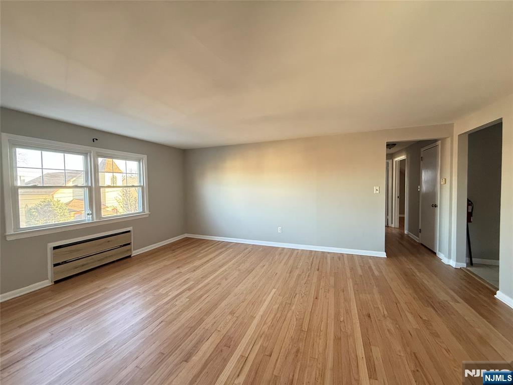 175 Van Winkle Street, Unit 2 East Rutherford, NJ 07073 - Photo 6 of 20 an empty room with wooden floor and windows