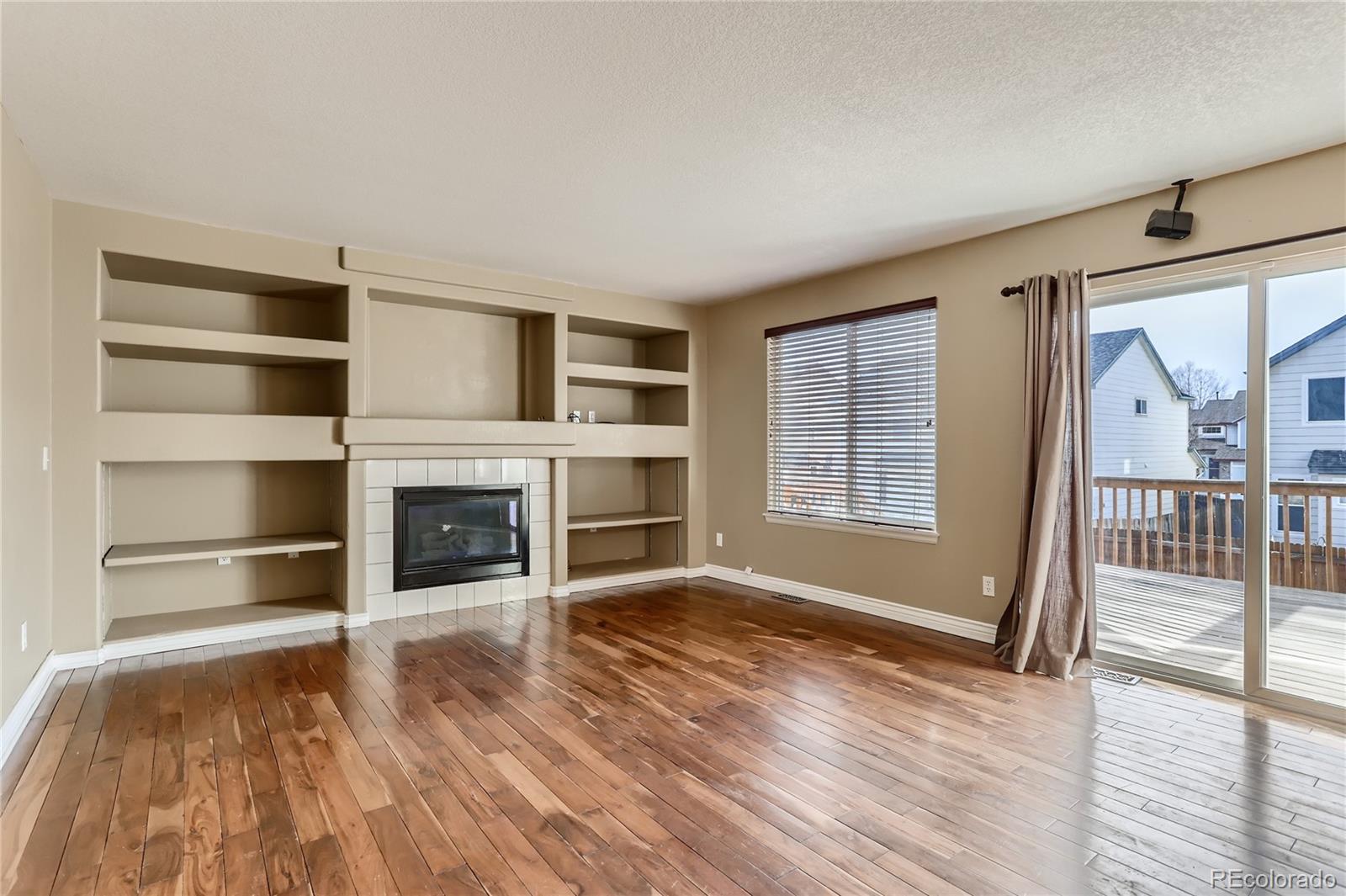 3905 South Kirk Way Aurora, CO 80013 - Photo 13 of 33 a view of a livingroom with a fireplace wooden floor and window