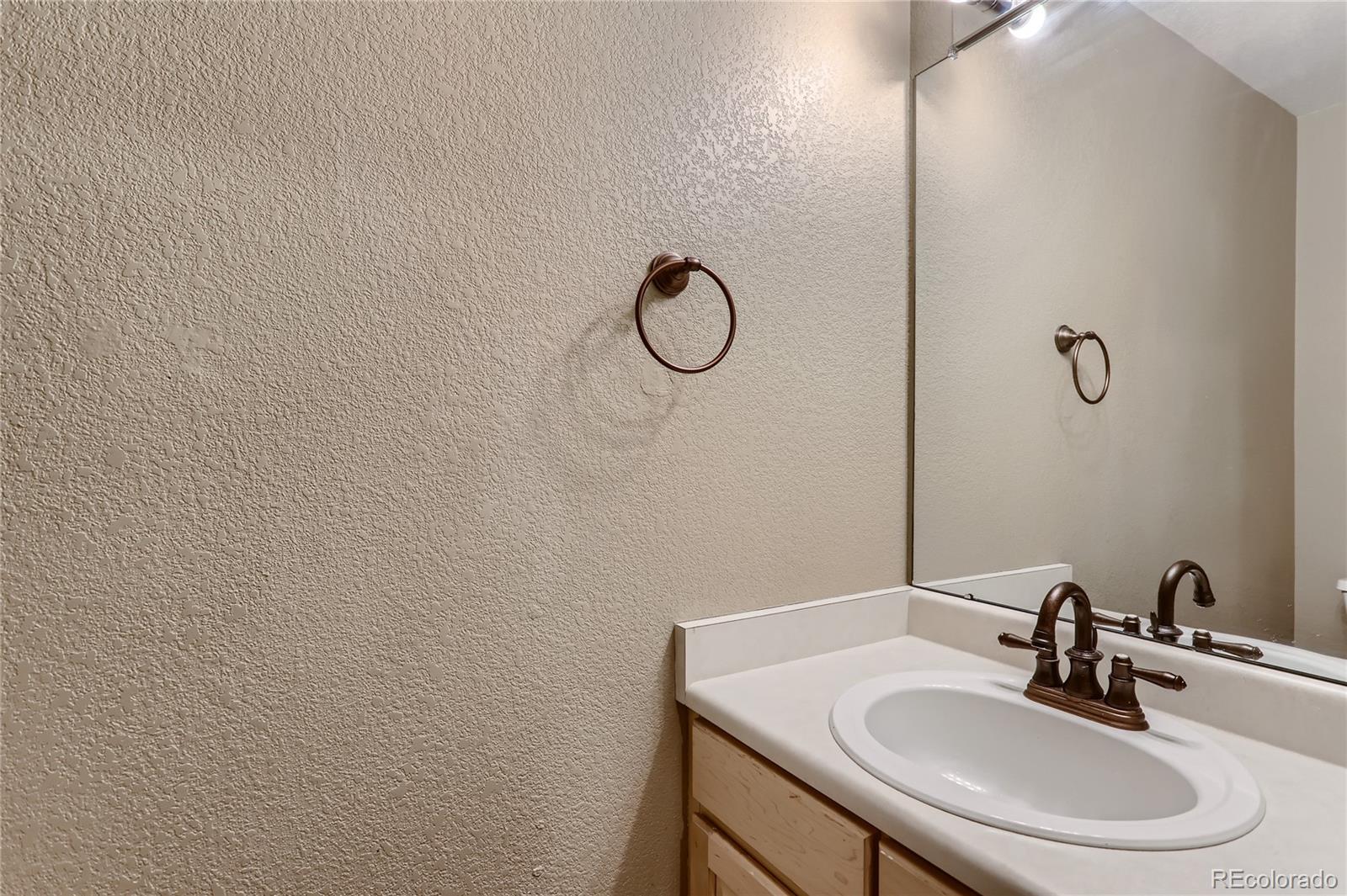 3905 South Kirk Way Aurora, CO 80013 - Photo 14 of 33 a bathroom with a sink toilet and mirror