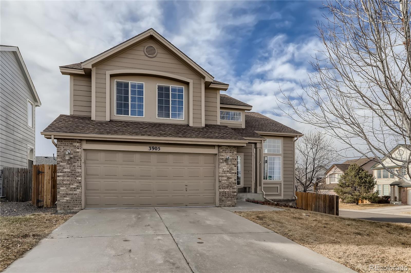 3905 South Kirk Way Aurora, CO 80013 - Photo 2 of 33 a front view of a house with a yard and garage