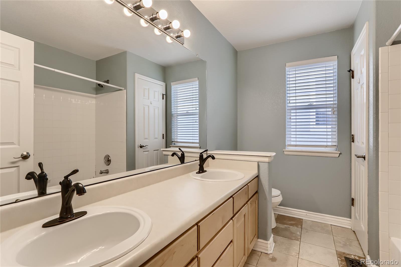 3905 South Kirk Way Aurora, CO 80013 - Photo 22 of 33 a bathroom with a sink and a large mirror