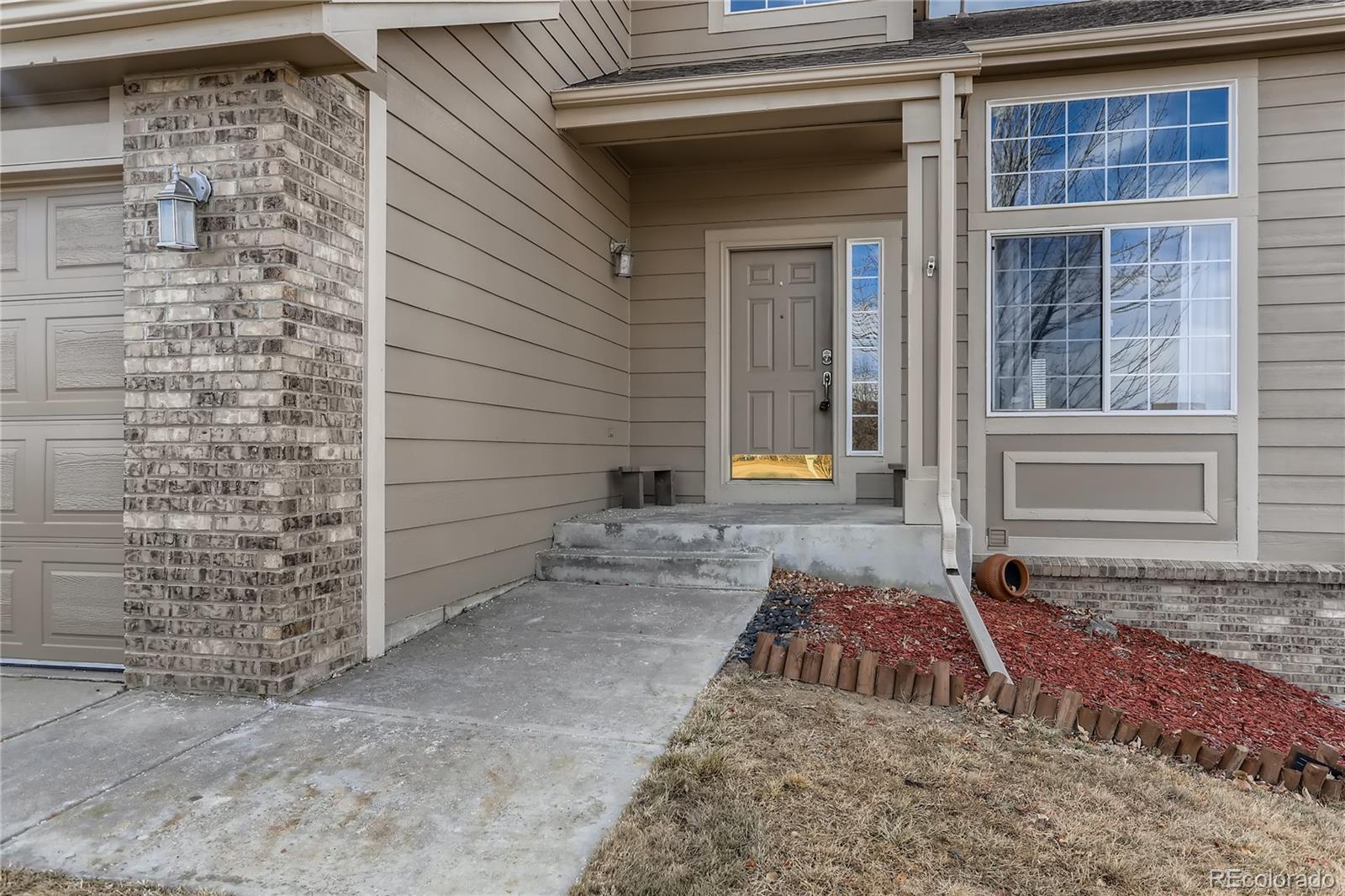 3905 South Kirk Way Aurora, CO 80013 - Photo 3 of 33 a view of a brick house with large windows