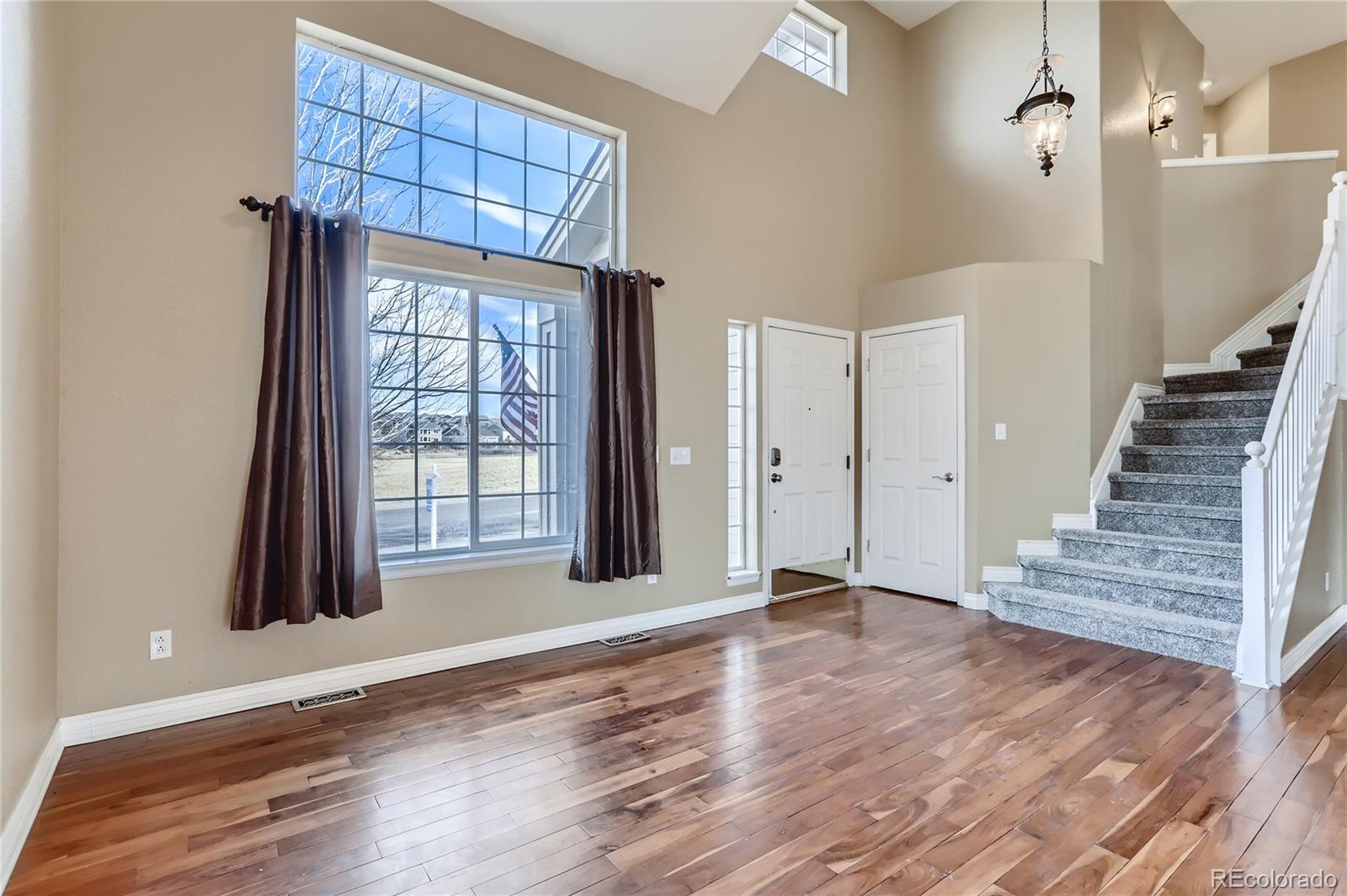3905 South Kirk Way Aurora, CO 80013 - Photo 5 of 33 a view of an empty room with wooden floor and a window