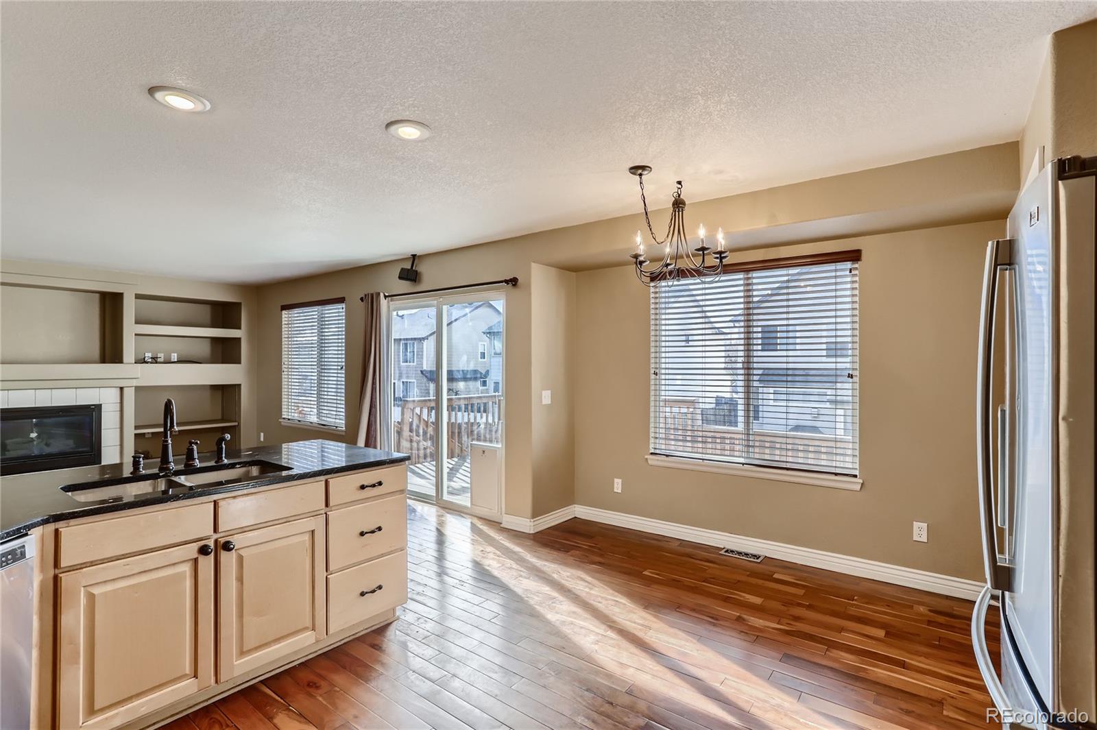 3905 South Kirk Way Aurora, CO 80013 - Photo 8 of 33 a kitchen with granite countertop cabinets stainless steel appliances and a large window