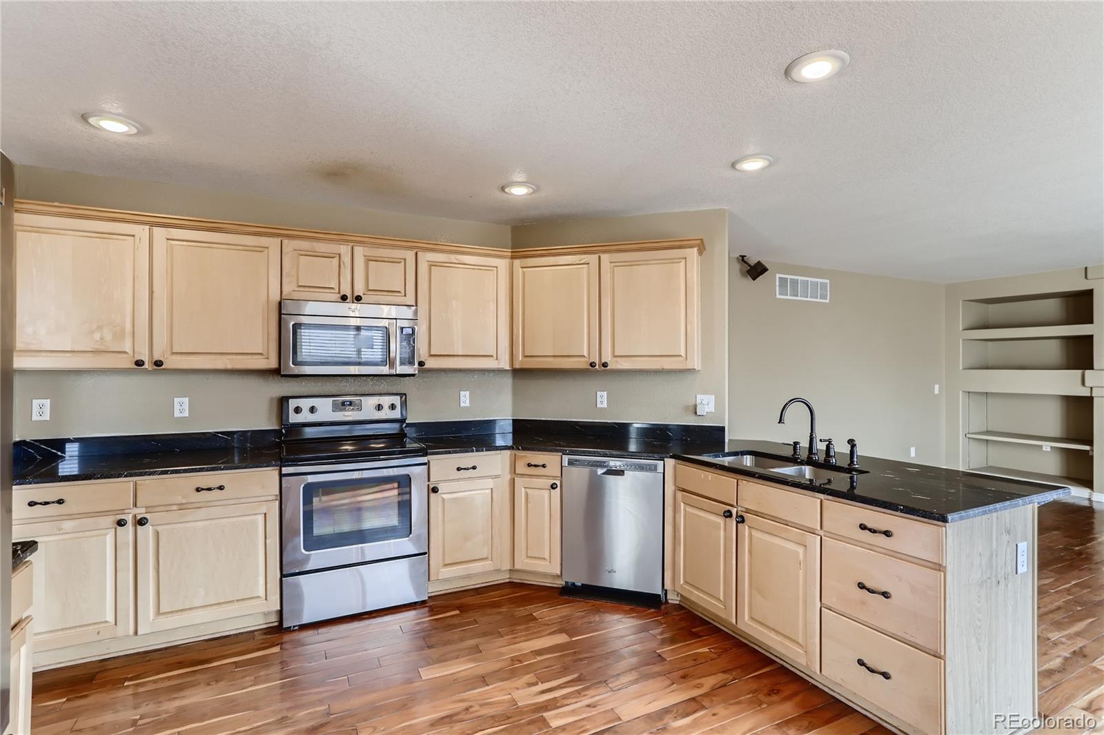 3905 South Kirk Way Aurora, CO 80013 - Photo 9 of 33 a kitchen with granite countertop a sink and cabinets