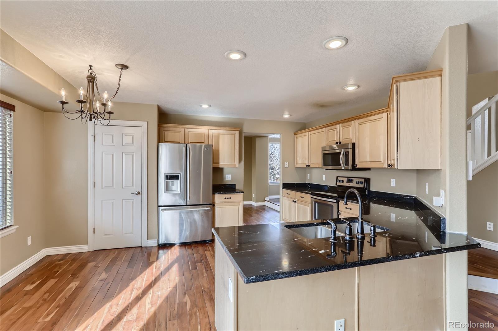 3905 South Kirk Way Aurora, CO 80013 - Photo 10 of 33 a kitchen with refrigerator and cabinets