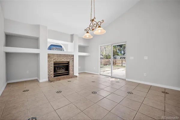 an empty room with windows and fireplace