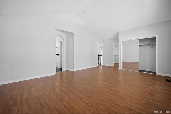 a view of empty room with wooden floor and window