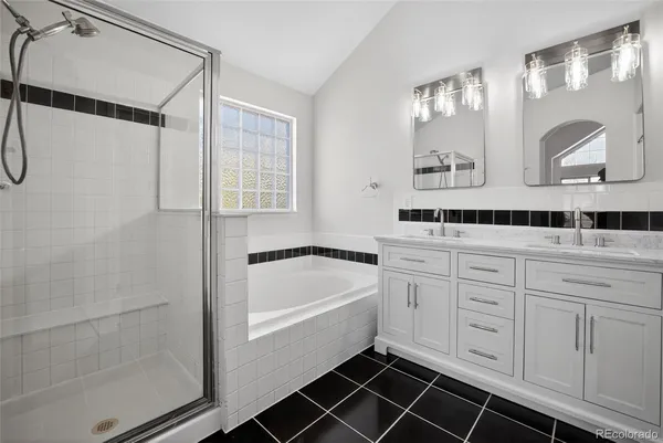 a spacious bathroom with a double vanity sink a mirror a shower and a window