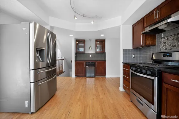a kitchen with stainless steel appliances wooden floor sink and stainless steel appliances