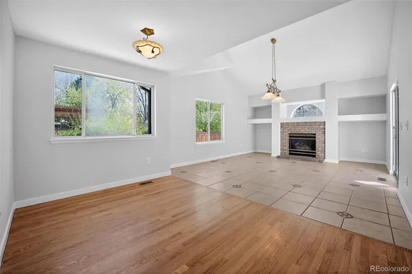 a view of an empty room with a fireplace and a window