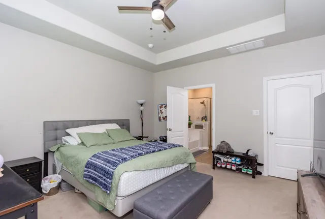 a bedroom with a bed mirror and couch
