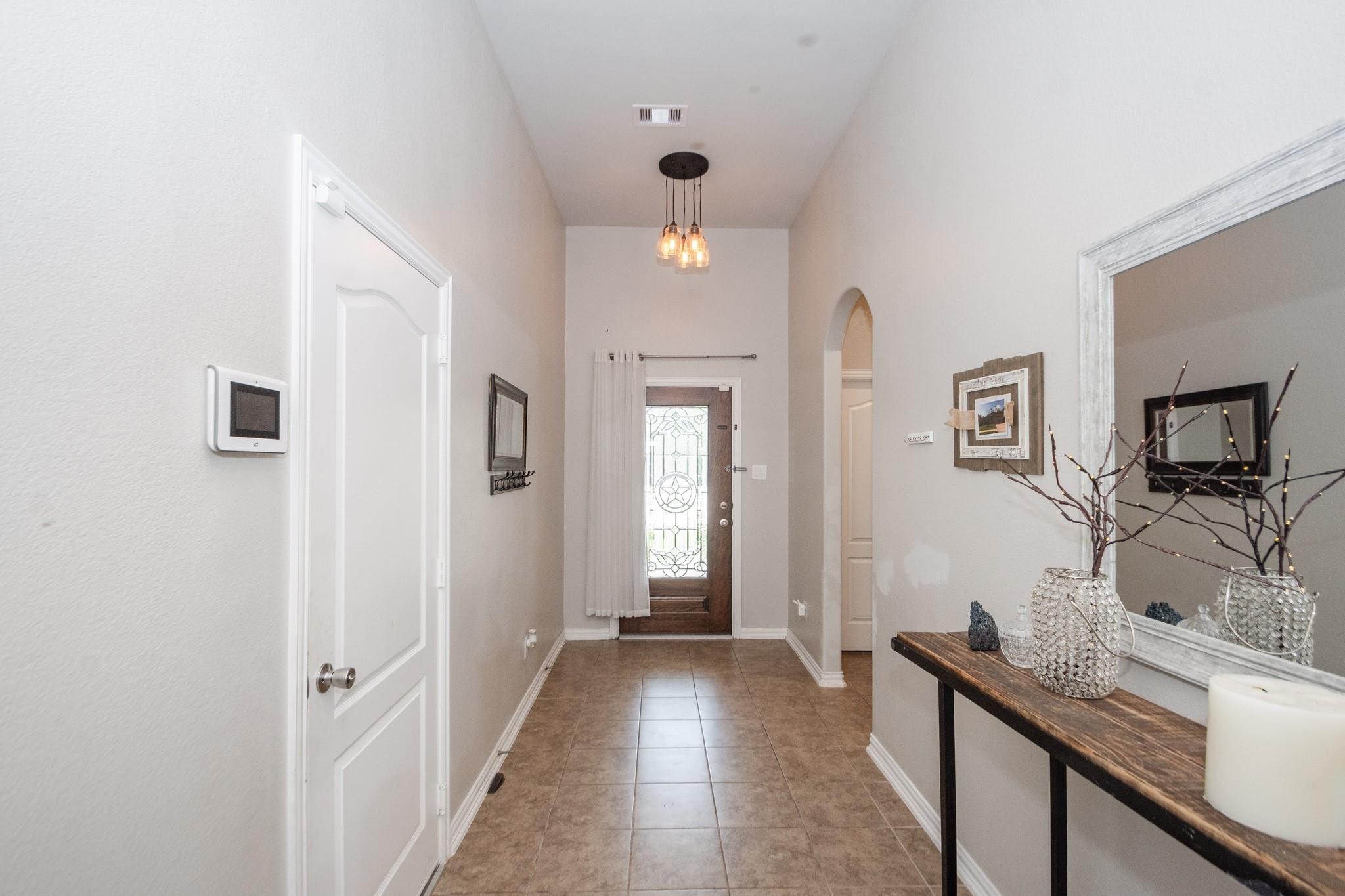 208 Timber Grove Court Clute, TX 77531 - Photo 4 of 22 This hallway features a tiled floor and neutral walls. The entrance door has glass detailing, providing a welcoming feel.