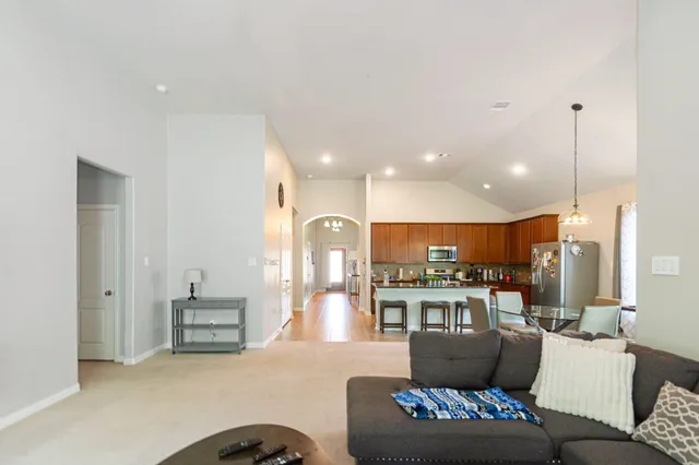 a living room with furniture and kitchen view
