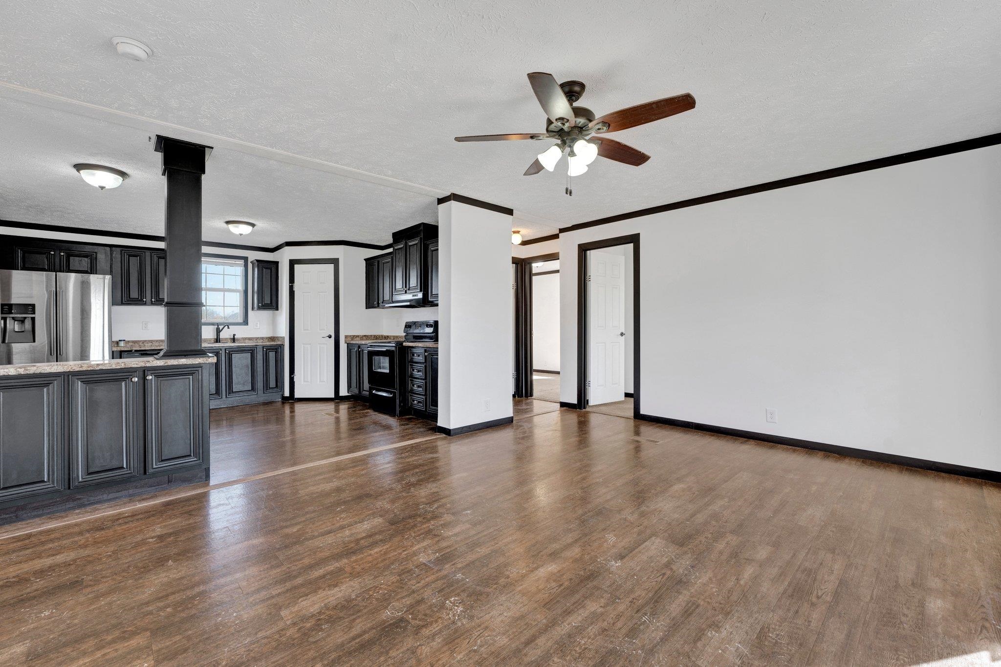 826 Nelson Road Brighton, TN 38011 - Photo 17 of 38 Unfurnished living room featuring dark hardwood / wood-style flooring, a textured ceiling, ceiling fan, crown molding, and sink