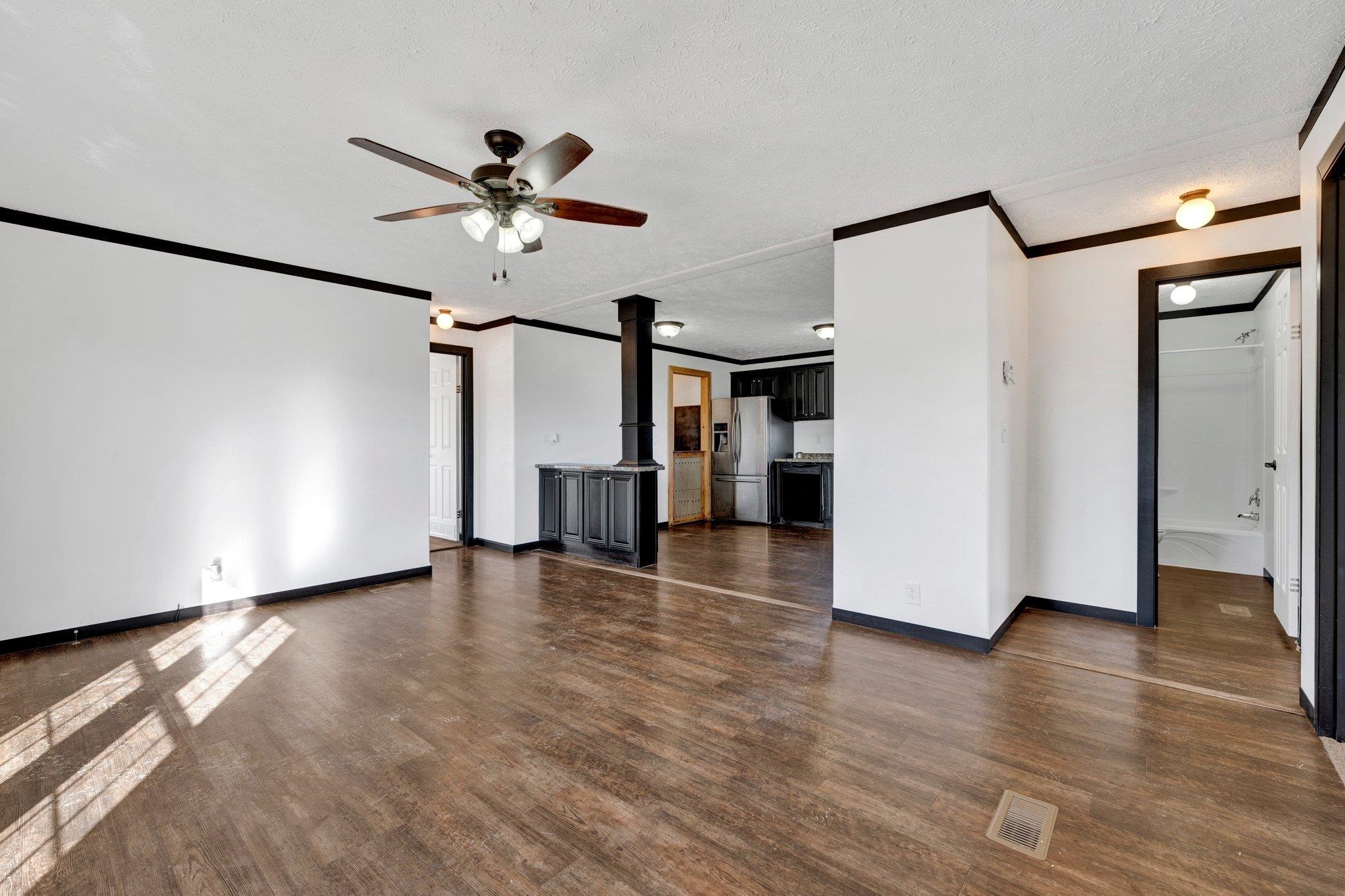 826 Nelson Road Brighton, TN 38011 - Photo 18 of 38 Unfurnished living room with ceiling fan, dark hardwood / wood-style floors, ornamental molding, and a textured ceiling