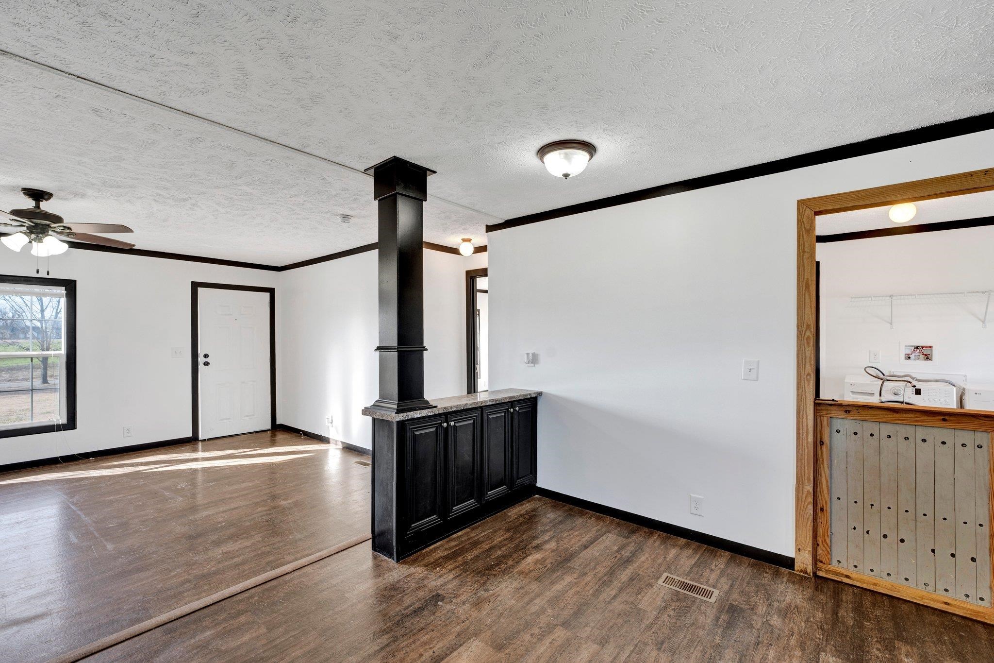 826 Nelson Road Brighton, TN 38011 - Photo 19 of 38 Unfurnished living room featuring crown molding, dark hardwood / wood-style flooring, ceiling fan, and a textured ceiling
