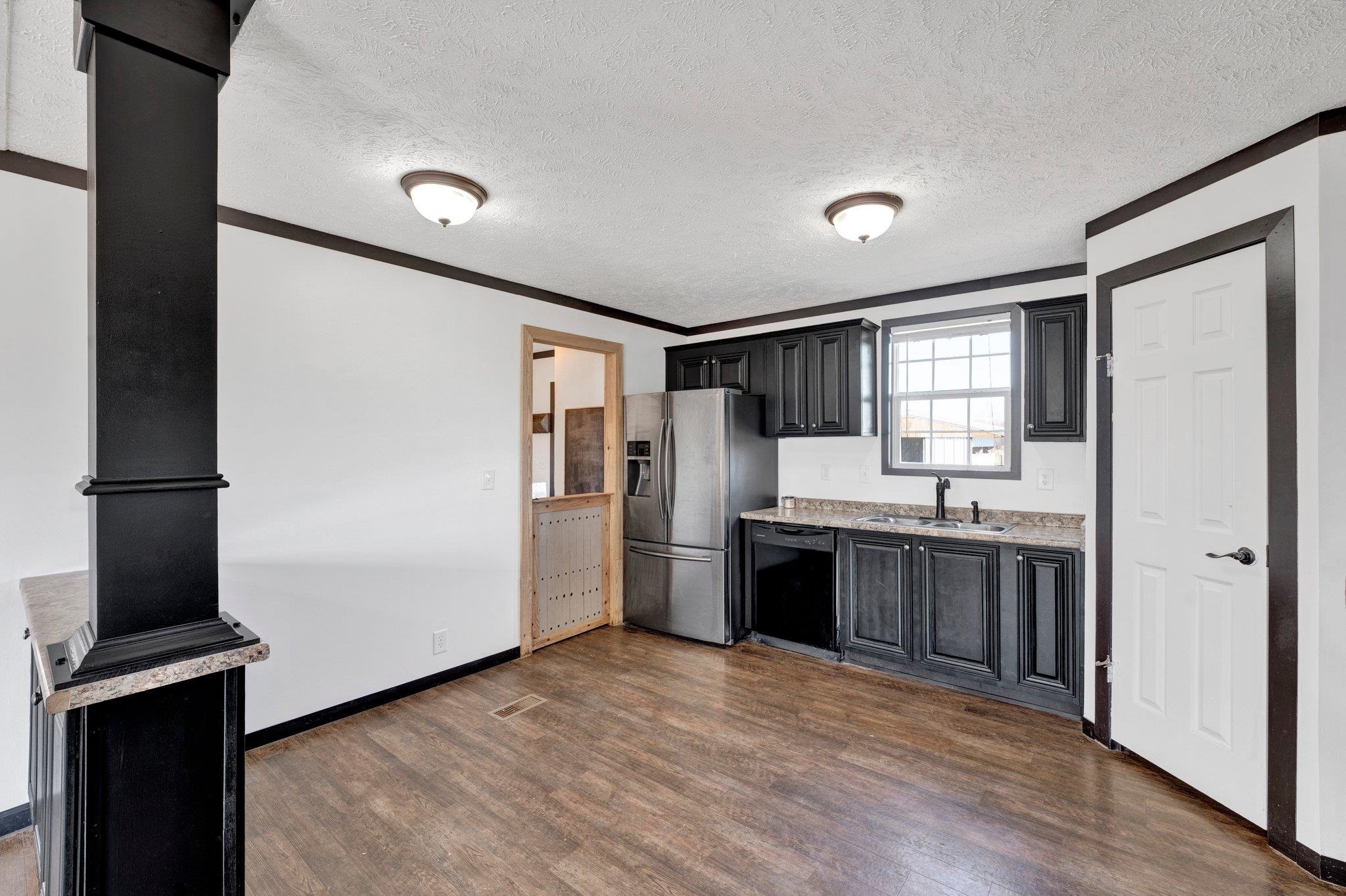 826 Nelson Road Brighton, TN 38011 - Photo 20 of 38 Kitchen featuring stainless steel fridge, dark hardwood / wood-style flooring, ornamental molding, sink, and black dishwasher